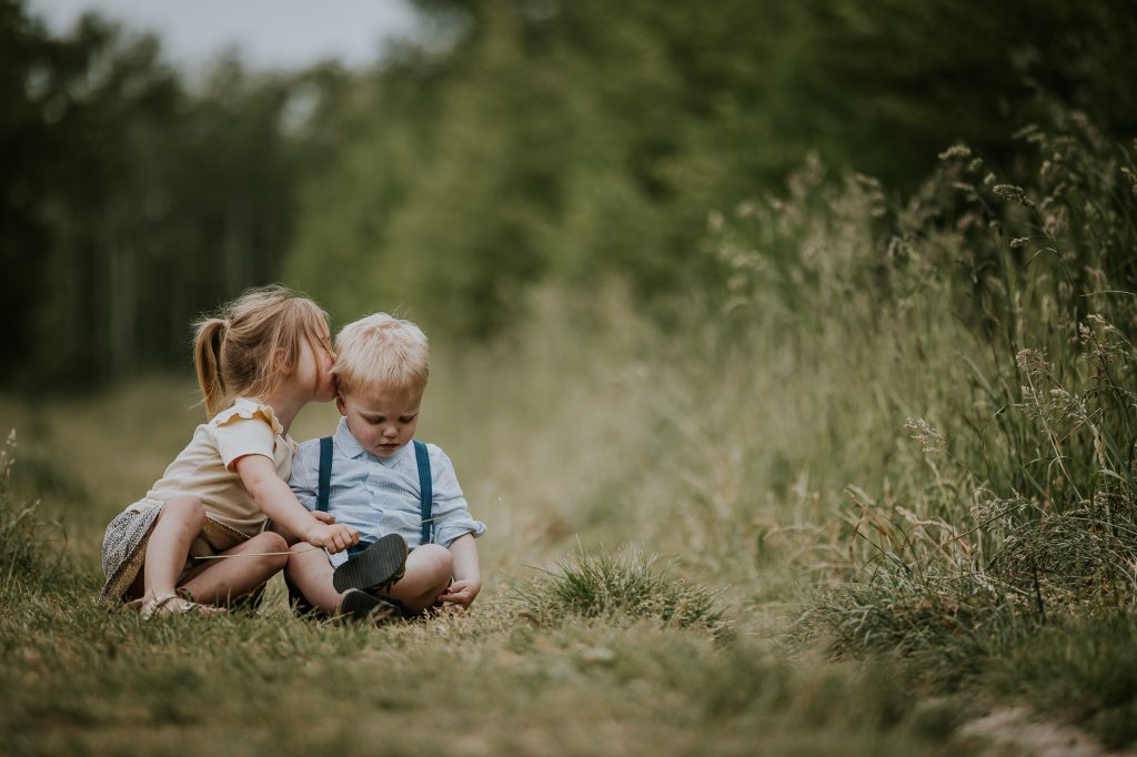Fotograaf Groningen, Nickie Fotografie. Kinderportret in nationaal natuurpark Lauwersmeer. Portret van broer en zus zittend in het gras.