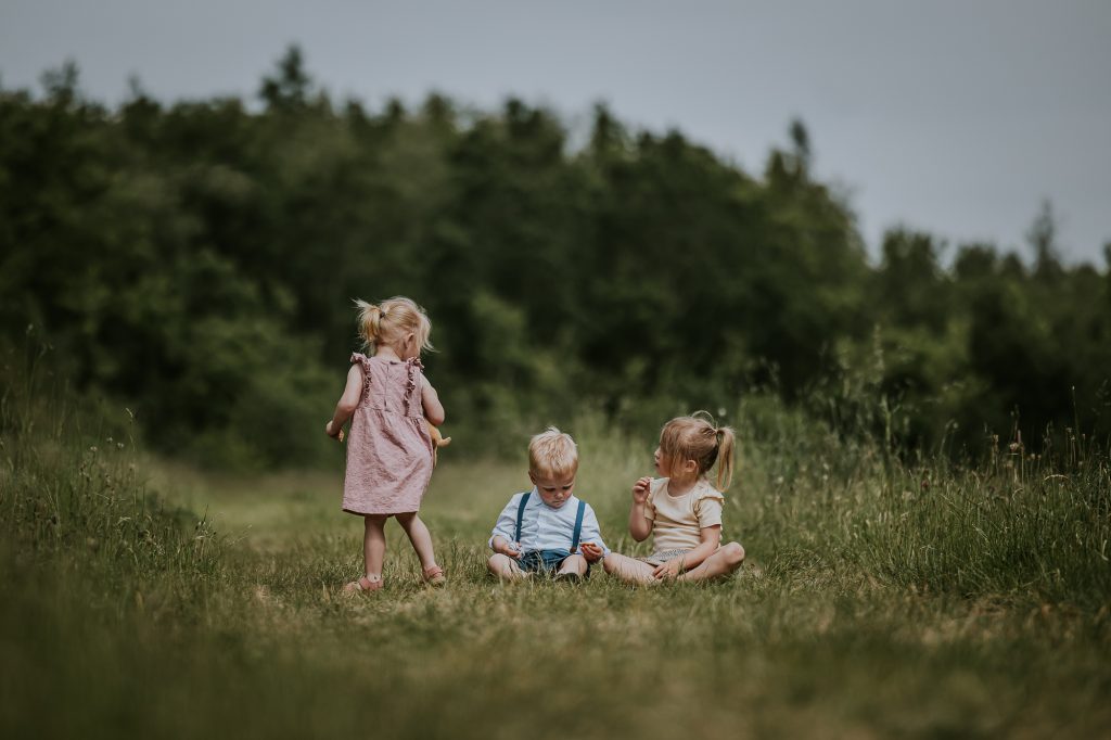 Kinderportret in het gras bij het Lauwersmeer door fotograaf Nickie Fotografie.