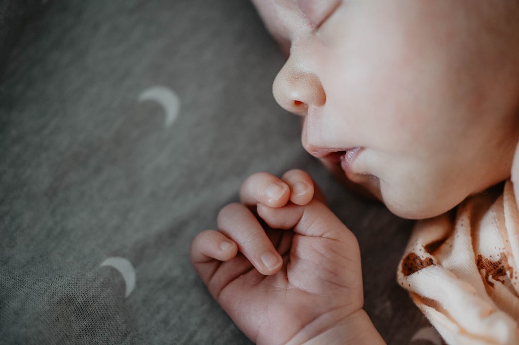 Newbornfotograaf Friesland, Nickie Fotografie. Schattig babyhandje terwijl het baby'tje heerlijk ligt te slapen.