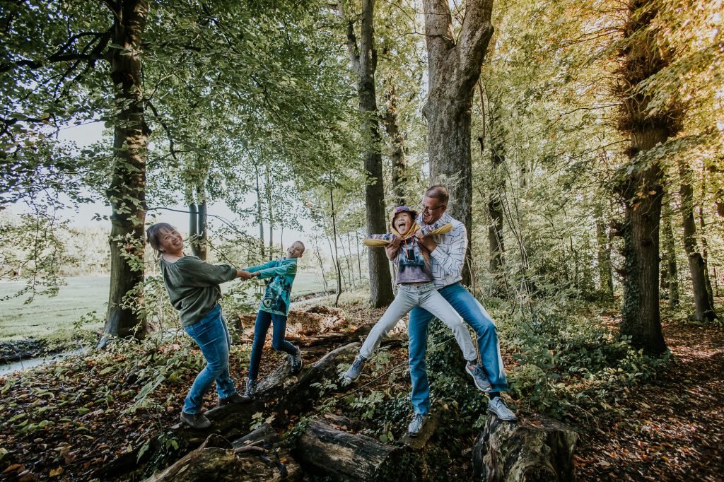 Speels gezinsportret in de bossen door portretfotograaf Nickie Fotografie uit Dokkum.