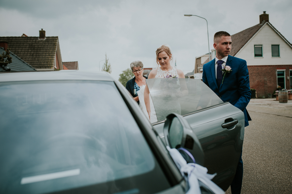 Bruiloft in Leek. bruidegom laat de bruid instappen in de trouwauto, Audi RS 7