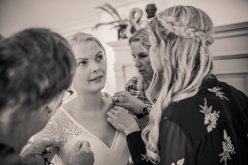 De bruid helpen met aankleden, door Nickie Fotografie.