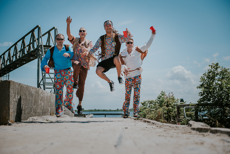 Actie portret van de mannen in hippie kleding tijdens de fotoshoot bij het Lauwersmeer door Nickie Fotografie