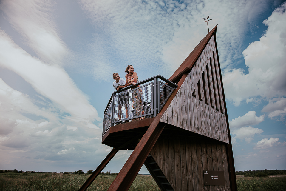 Fotoshoot in natuurgebied Lauwersoog. Moeder en zoon in de uitkijktoren, kijkend over het natuurgebied.