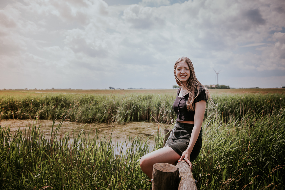 Portret van tienermeisje op een hek bij natuurgebied Lauwersoog, door portretfotograaf Nickie Fotografie uit Dokkum , Friesland