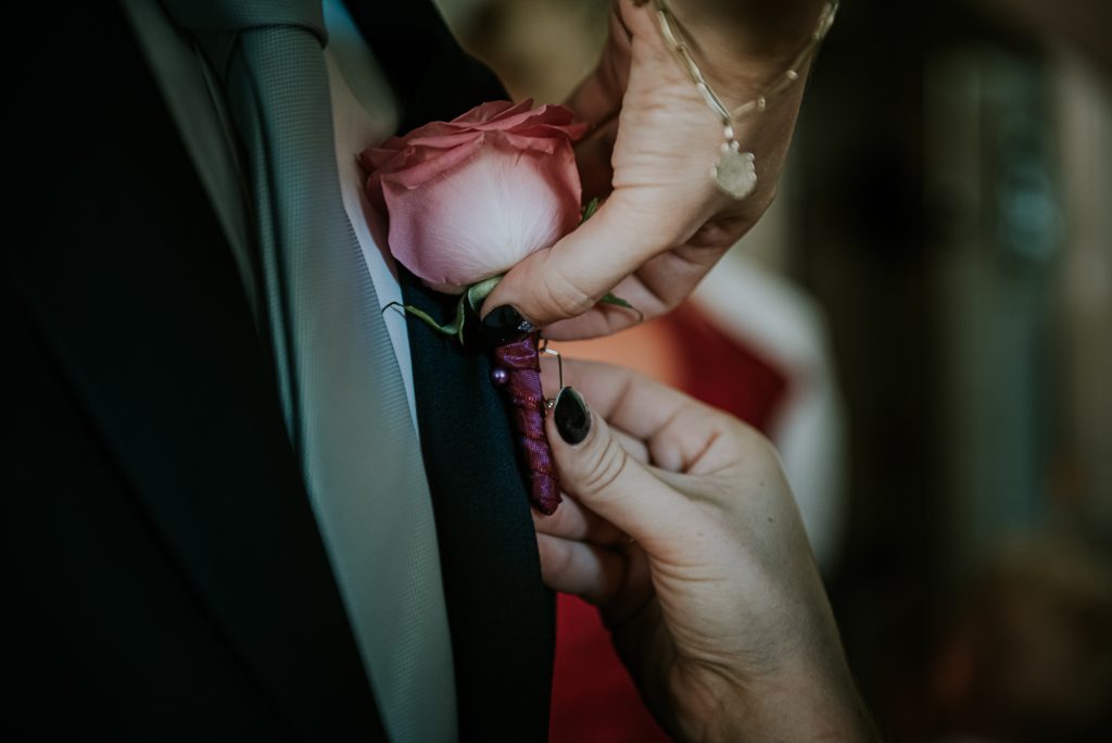 Het vastmaken van de corsage. Trouwreportage door Nickie Fotografie uit Dokkum