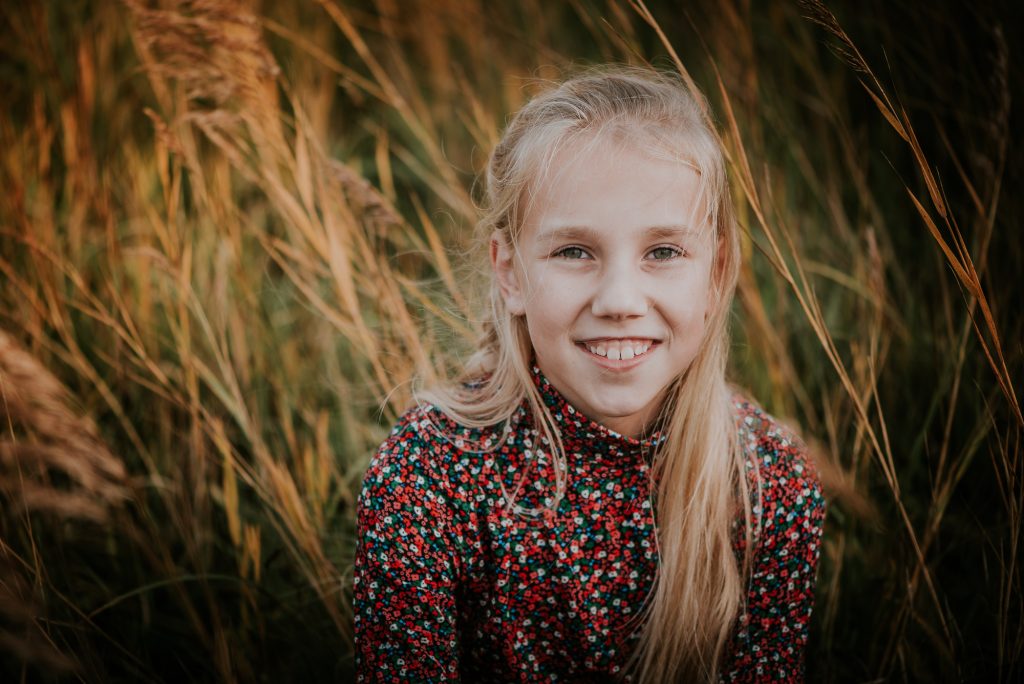 Herfstshoot in Friesland. Portret van meisje in het hoge gras door portretfotograaf Nickie Fotografie uit Dokkum
