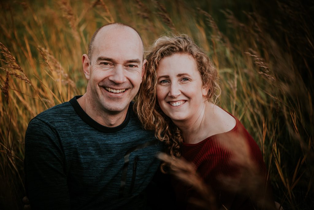 Portret van de ouders in het hoge gras door familiefotograaf Nickie Fotografie uit Dokkum