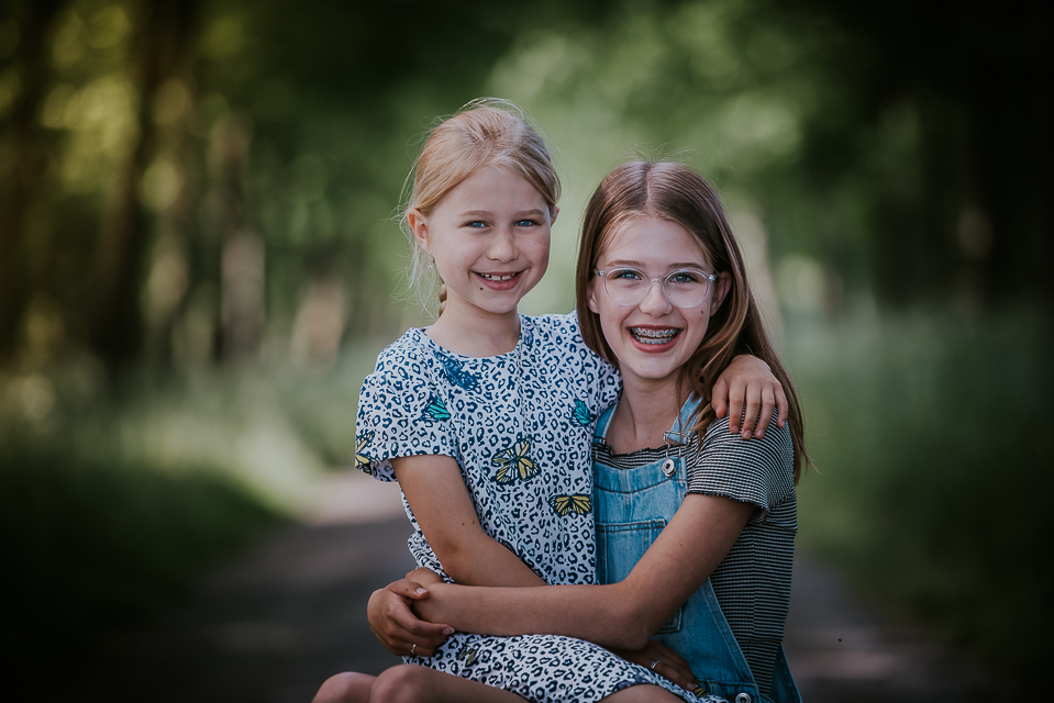Gezinsportretten. Portret van 2 zusjes op een prachtig landweggetje door Nickie fotografie