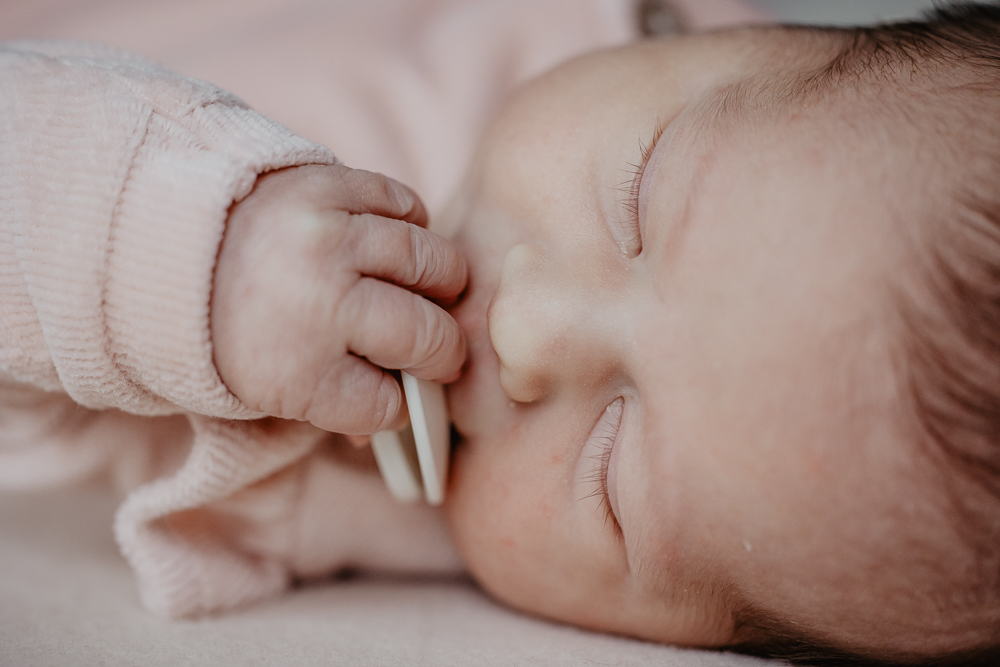 Newbornfotograaf Heerenveen, Nickie Fotografie. Baby houdt haar speen vast terwijl ze slaapt.