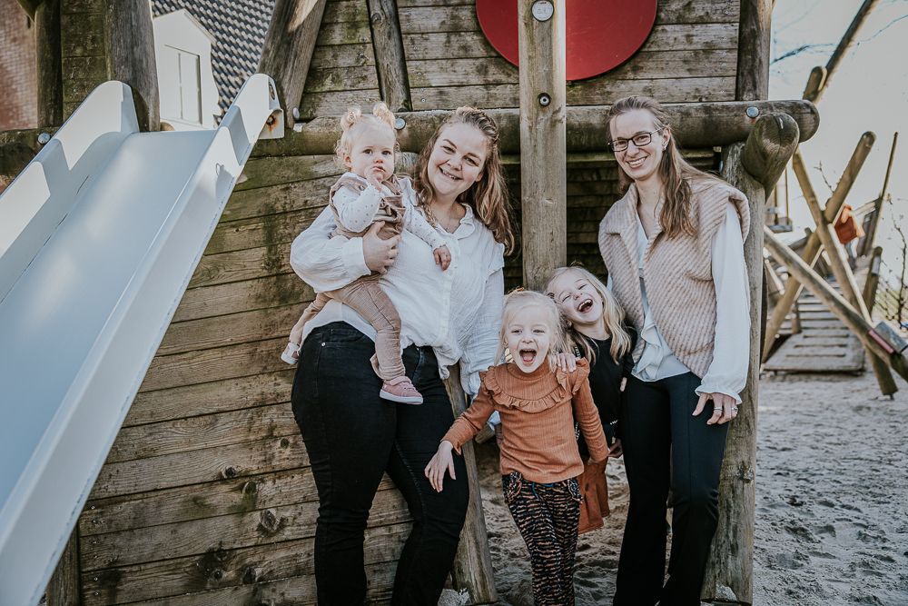 Familieshoot in de speeltuin van Esonstad door Nickie Fotografie. Portret van de meiden bij de glijbaan.
