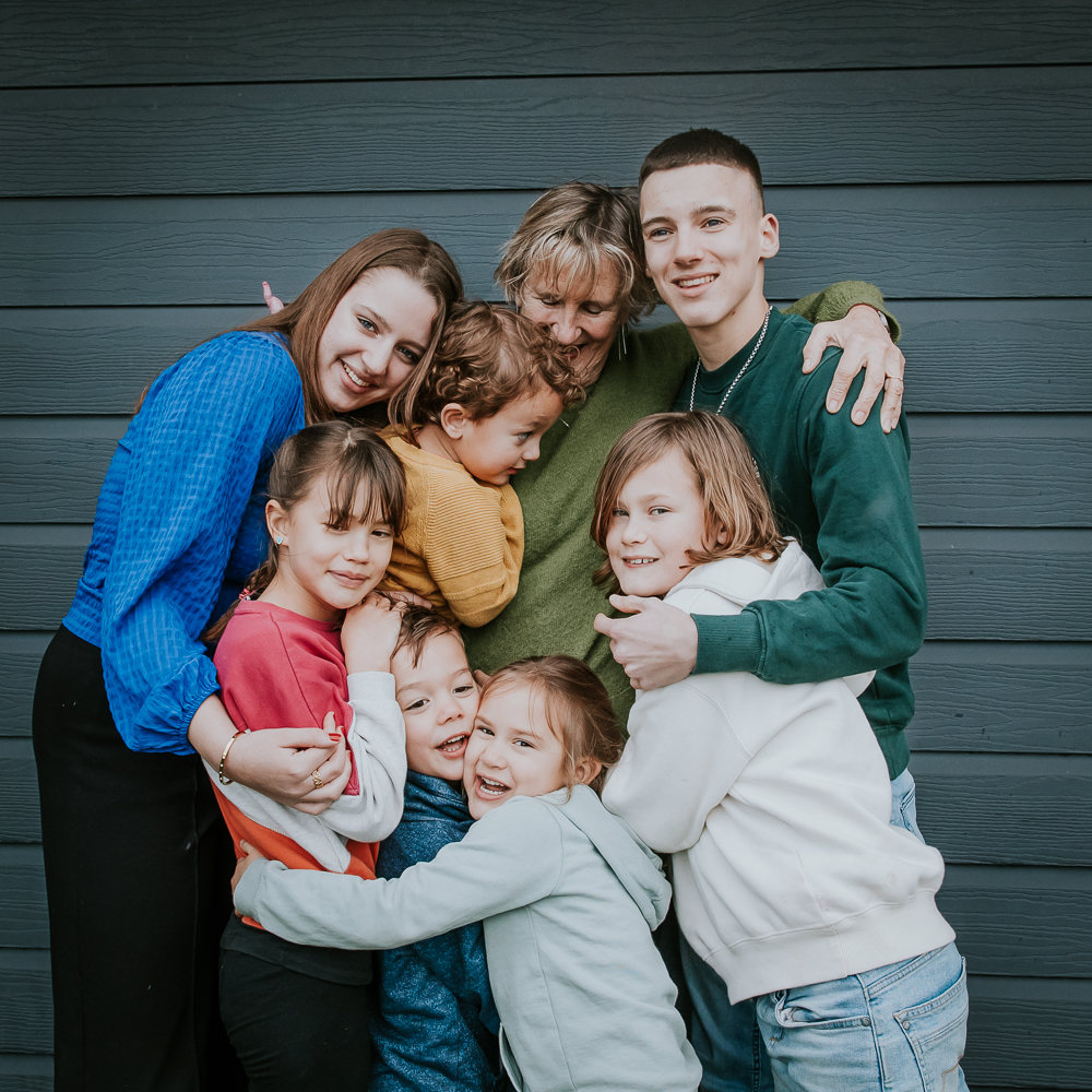 Familieshoot Julianadorp. Oma knuffelt al haar kleinkinderen bij het vakantie huisje in landal Ooghduyne. Fotoshoot door fotograaf Nickie Fotografie.