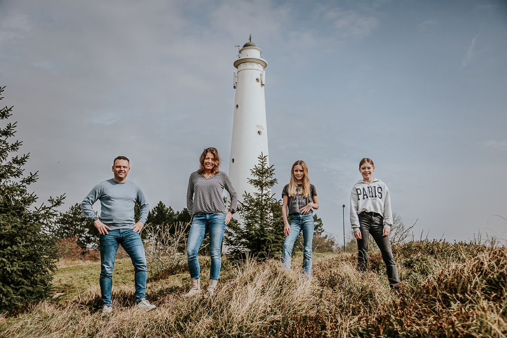 Fotograaf Schiermonnikoog. Stoer gezinsportret voor de oude witte vuurtoren/watertoren, de Zuidertoren door Nickie Fotografie uit Friesland.