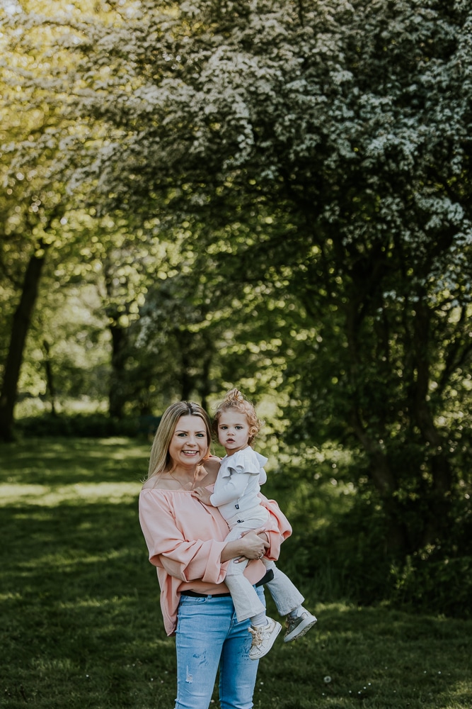 Fotograaf Friesland. Portret van moeder en peuter dochter voor een boom in witte bloesem door Nickie Fotografie.