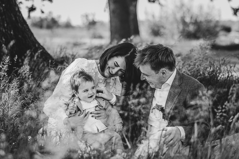Zwart-wit trouwreportage Friesland. Gezellige gezinsfoto in het hoge gras door bruidsfotograaf Nickie Fotografie.