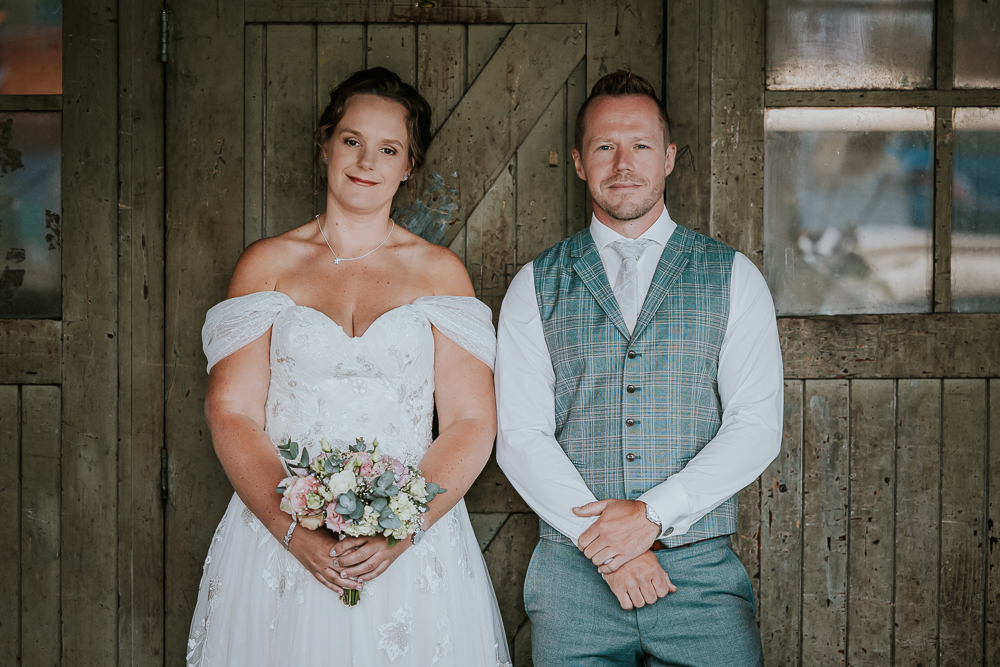 Fotograaf Friesland. Bruidsportret voor oude houten deur in de Sluisfabriek door bruidsfotograaf Nickie Fotografie uit Friesland.