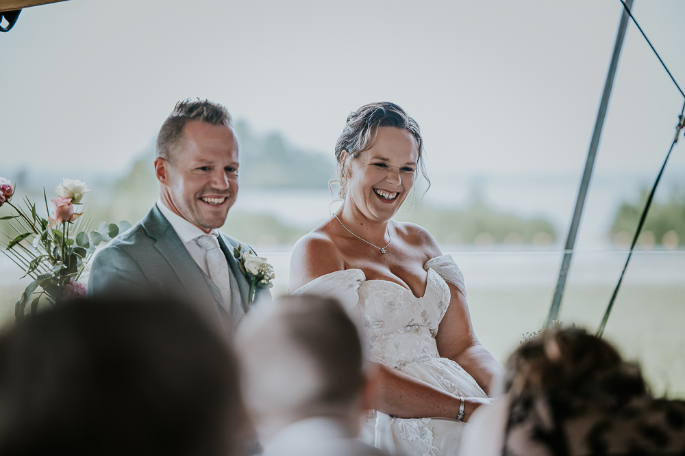 Trouwen bij de Leyen. Lachend bruidspaar tijdens de trouwceremonie. Bruidsreportage door huwelijksfotograaf Nickie Fotografie uit Friesland.