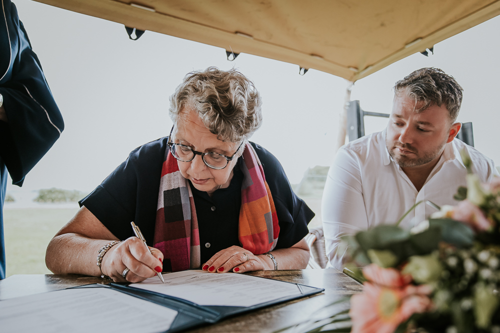 Het ondertekenen van de trouwakte door de getuigen. Bruidsfotografie door trouwfotograaf Nickie Fotografie uit Friesland. Trouwen bij de Leyen.