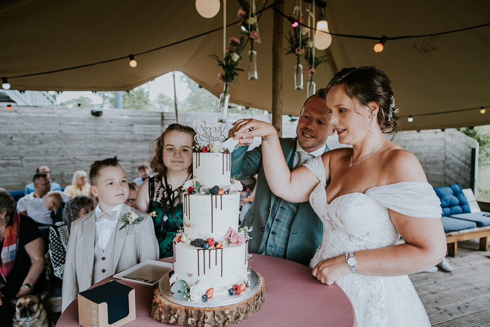 Het aansnijden van de bruidstaart. Huwelijksfotografie door trouwfotograaf Nickie Fotografie uit Friesland.