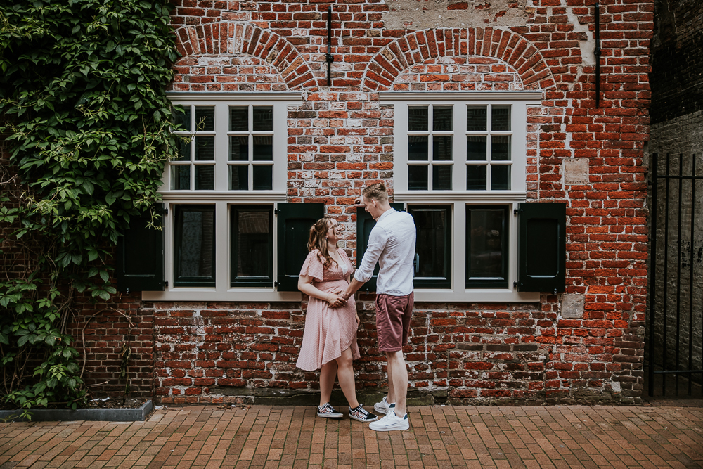 Fotograaf Dokkum.  Zwangerschapsfotografie door Nickie Fotografie uit Friesland. De aanstaande ouders staan bij oude muur.