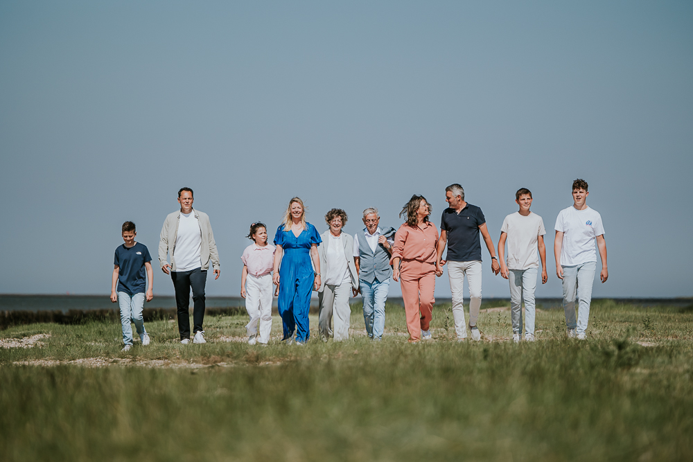 Familieshoot Moddergat door fotograaf Nickie Fotografie uit Friesland. Portret van de familie aan de wandel achter de zeedijk.