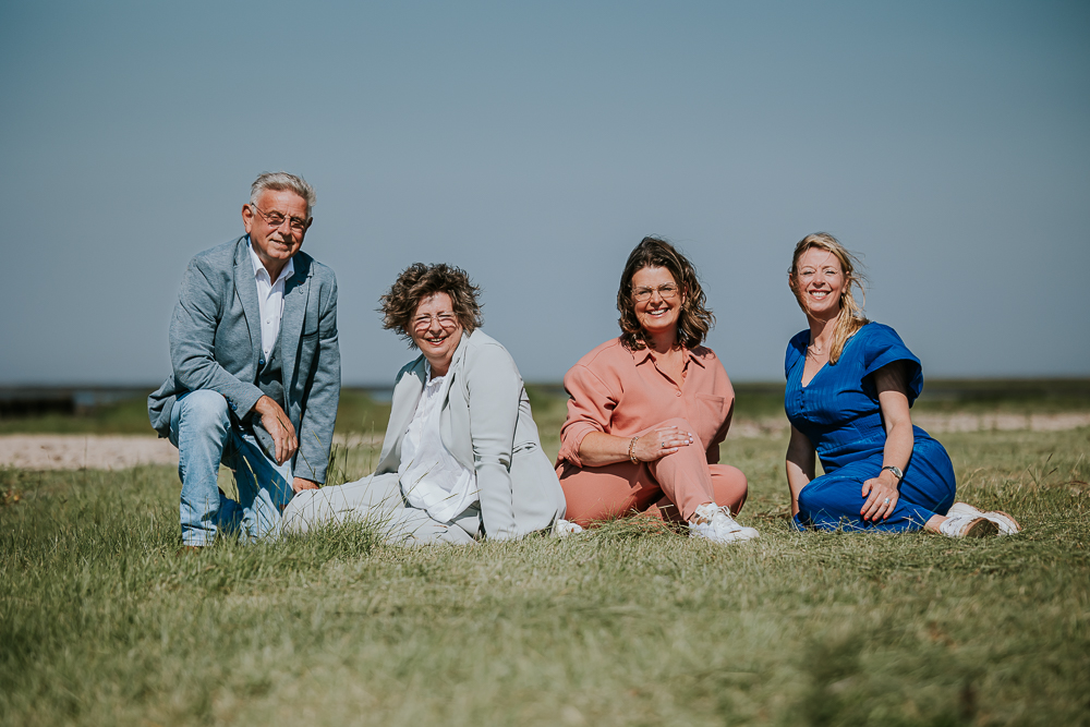 Fotograaf Friesland. Portret van het originele gezin op het gras achter de zeedijk door fotograaf Nickie Fotografie uit Friesland.