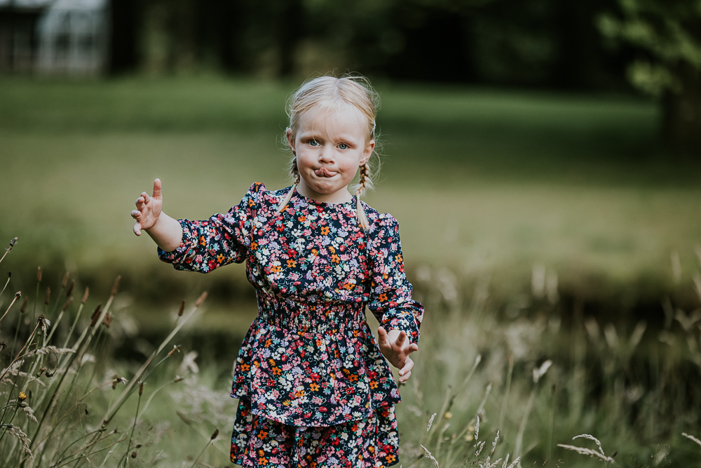 Fotograaf Dokkum. Kinderportret van blond meisje met vlechtjes en in bloemetjesjurk door Nickie Fotografie.