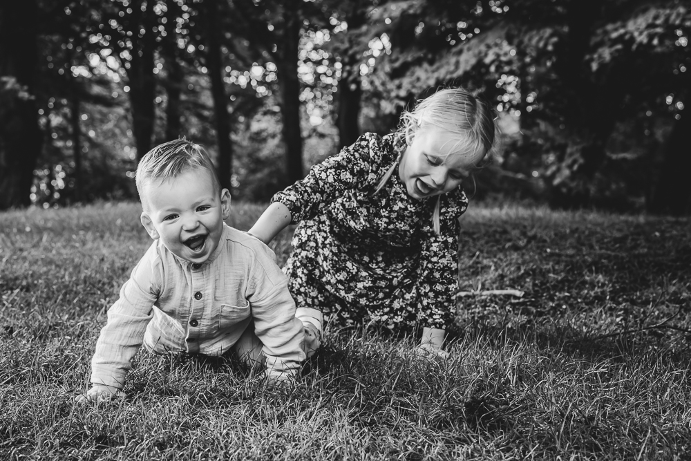 Fotograaf Dokkum. Zwart-wit portret van spelende kinderen in het gras door Nickie Fotografie.