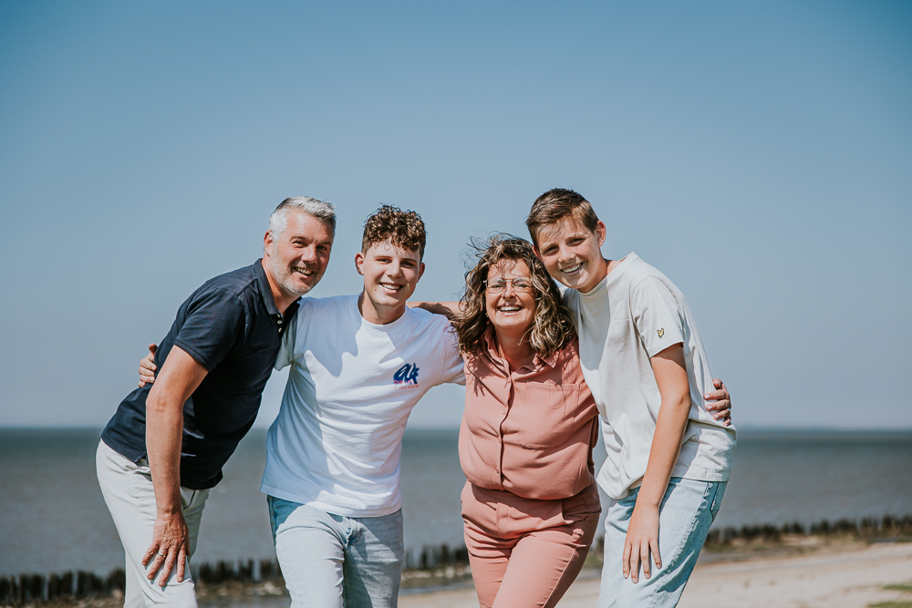 Gezellig gezinsportret boven op de zeedijk door fotograaf Nickie Fotografie uit Friesland.