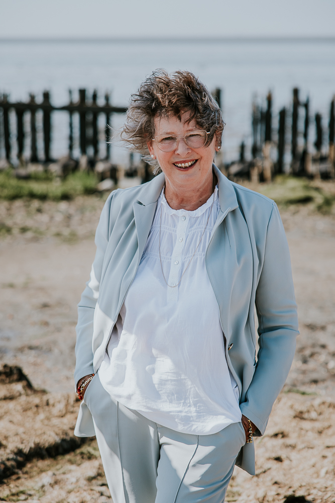 Fotograaf Friesland. Portret van oma bij de paaltjes aan de Waddenzee door Nickie Fotografie uit Dokkum.