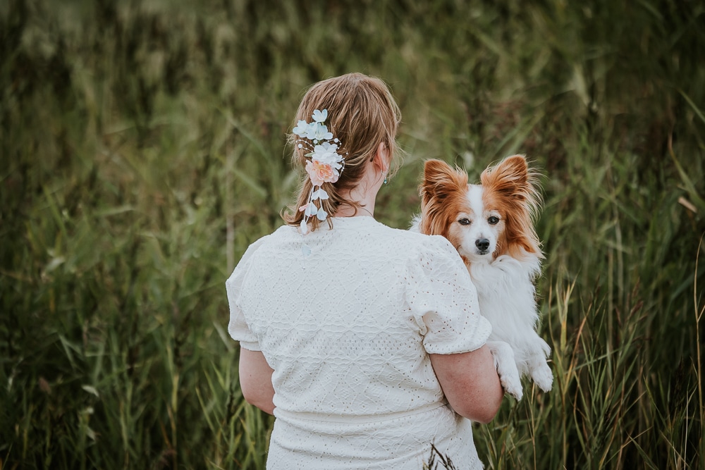 Bruid met haar hondje in de duinen. Trouwreportage door trouwfotograaf Nickie Fotografie uit Dokkum, Friesland.