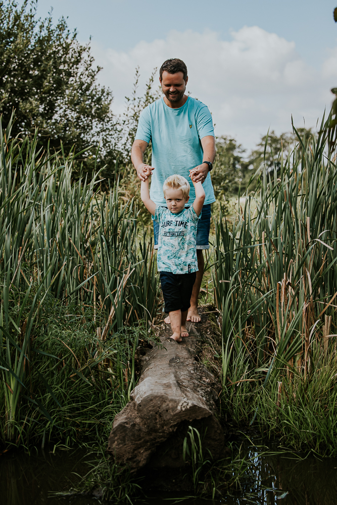 Fotoshoot Groningen. Vader en peuter zoon lopen over de boom. Lifestyle gezinsshoot door fotograaf Nickie Fotografie.