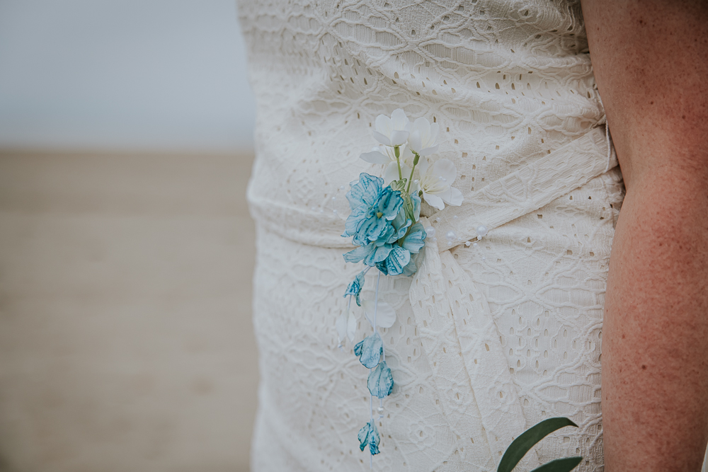 Detail van het bloemetje op de bruidsjurk. Trouwfotografie door huwelijksfotograaf Nickie Fotografie uit Friesland.