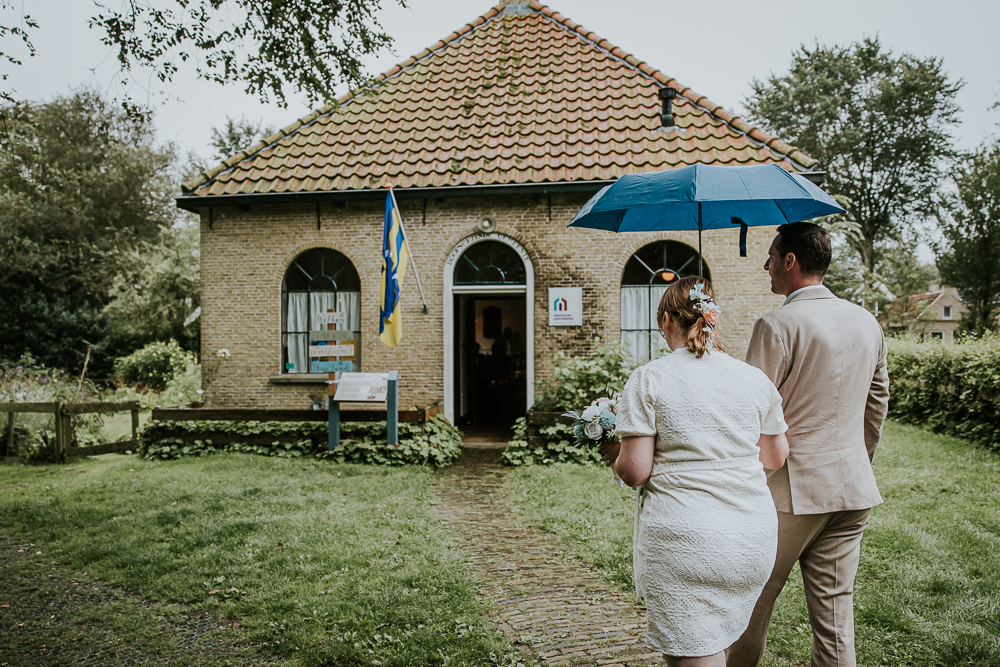 Trouwen op Ameland. Het bruidspaar loopt naar het oude doopsgezinde kerkje op de Vermaningspad. Trouwreportage door bruidsfotograaf Nickie Fotografie uit Friesland.