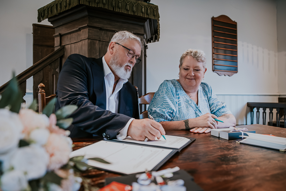 De getuigen ondertekenen de huwelijksakte. Trouwreportage door huwelijksfotograaf NIckie Fotografie uit Friesland.