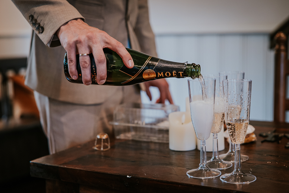 Het inschenken van de champagne op de trouwerij door de bruidegom zelf. Trouwreportage door bruidsfotografie Nickie Fotografie uit Friesland.