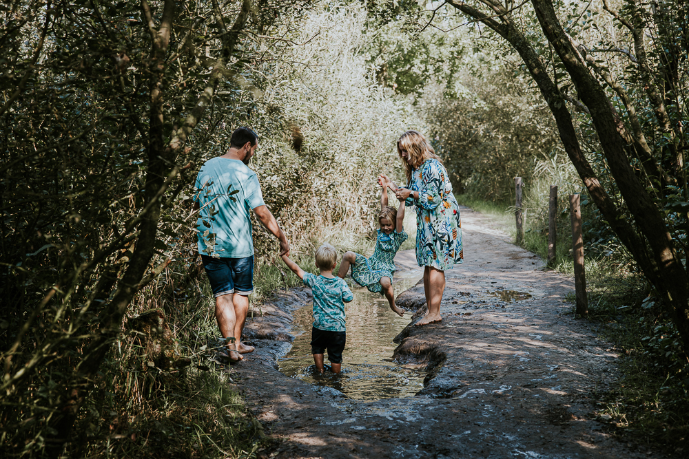 Blote voetenpad wandeling bij Opende. Het gezin speelt bij een waterplas op een schattig modderpaadje. Lifestyle gezinsshoot door fotograaf Nickie Fotografie uit Friesland.