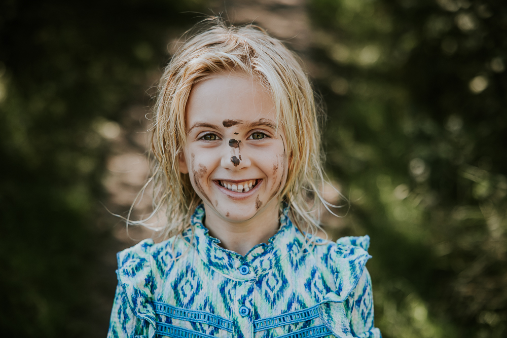 Fotoshoot Groningen. Kinderportret, van een meisje dat helemaal vies is geworden tijden de blotevoetenpad wandeling in Opende., door fotograaf Nickie Fotografie.