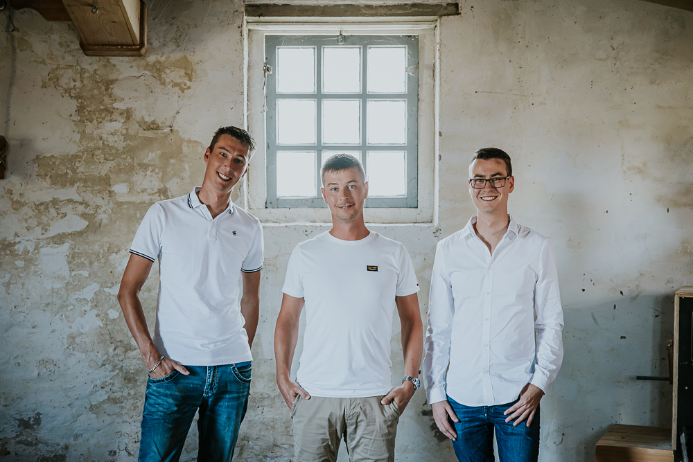 Portret van de drie zonen voor het raampje van de molen. Gezinsshoot door fotograaf NIckie Fotografie uit Dokkum, Friesland.