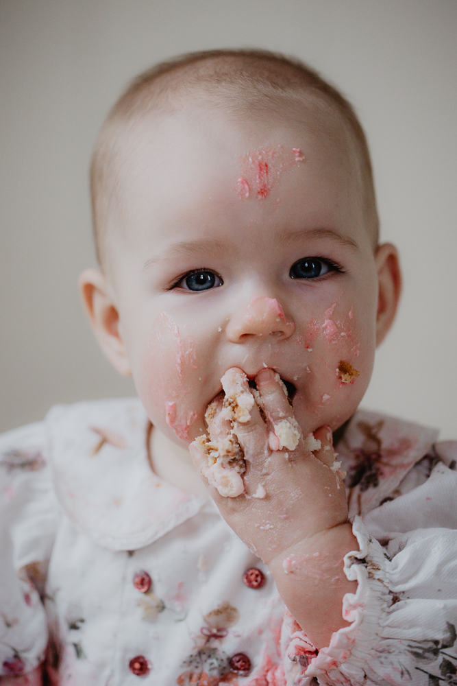 Dreumes eet haar taart met haar handen. Verjaardagsshoot door fotograaf Nickie Fotografie.