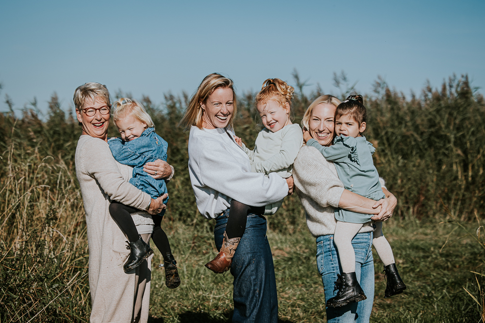 Fotograaf Lauwersoog. Gezellig portret van de dames in het natuurgebied. Elke volwassene houdt een kind vast. Fotoreportage door Nickie Fotografie.