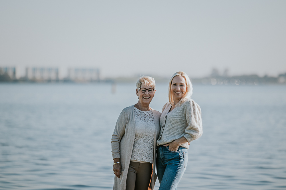 Portret van moeder en dochter met op de achtergrond de sluizen van lauwersoog. Fotoshoot door fotograaf Nickie Fotografie uit Friesland.