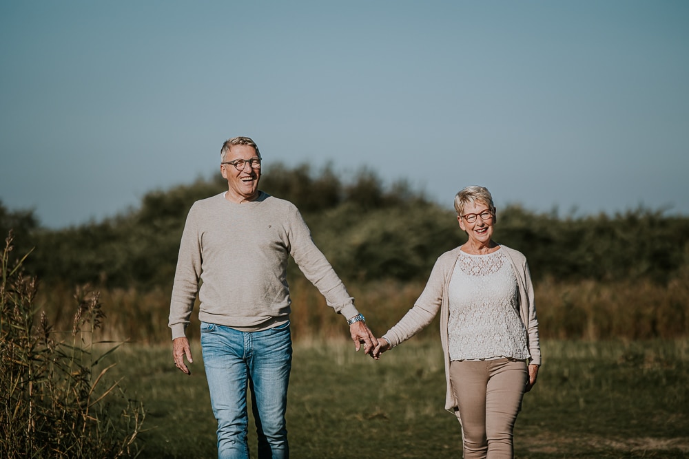 Fotograaf Friesland. Portret van opa en oma die hand in hand aan het wandelen zijn in Lauwersoog. Familie fotosessie door Nickie Fotografie uit Dokkum.