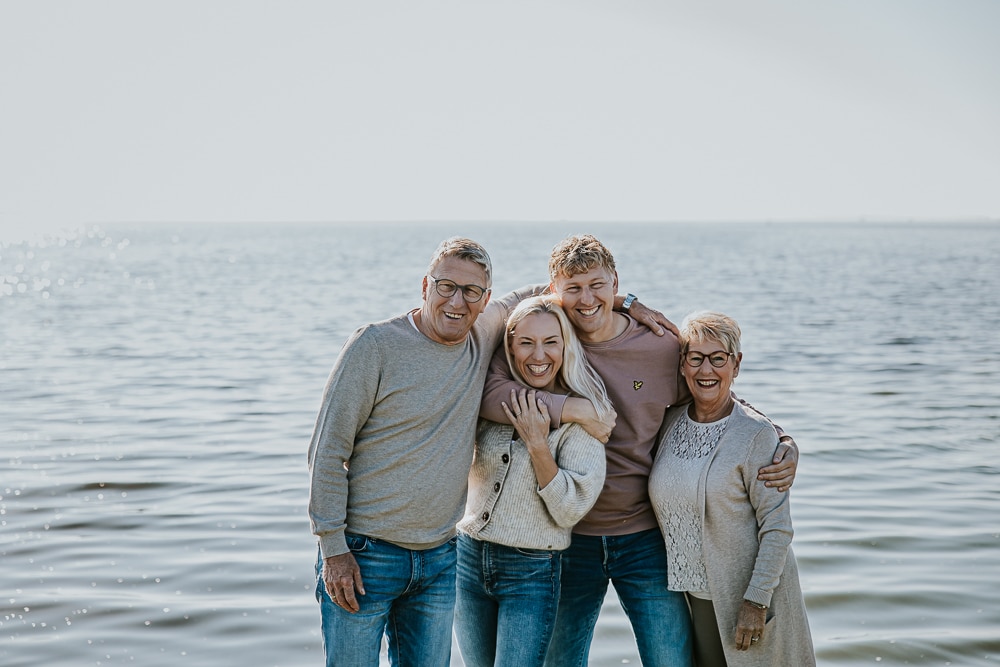 Fotograaf Lauwersoog. Knuffel portret van het originele gezin bij het water door Nickie Fotografie.