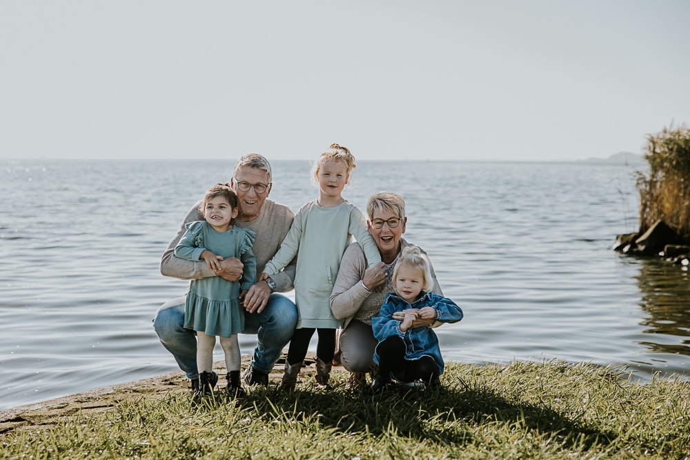 Portret van opa en oma met hun kleinkinderen bij het water door fotograaf Nickie Fotografie uit Dokkum, Friesland.