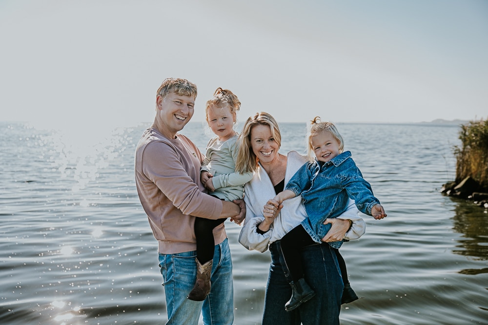 Fotoshoot Lauwersoog door fotograaf Nickie Fotografie. Vrolijk gezinsportret bij het water.