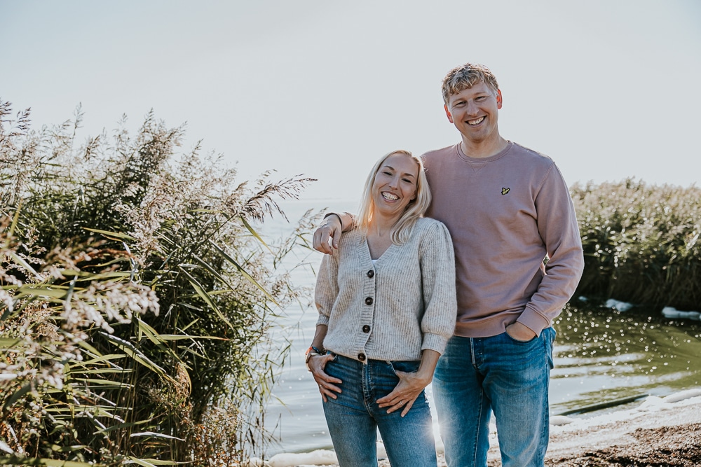 Portret van broer en zus voor het water en naast het riet. Familiefotoshoot bij het Lauwersmeergebied door fotograaf Nickie Fotografie uit Friesland.