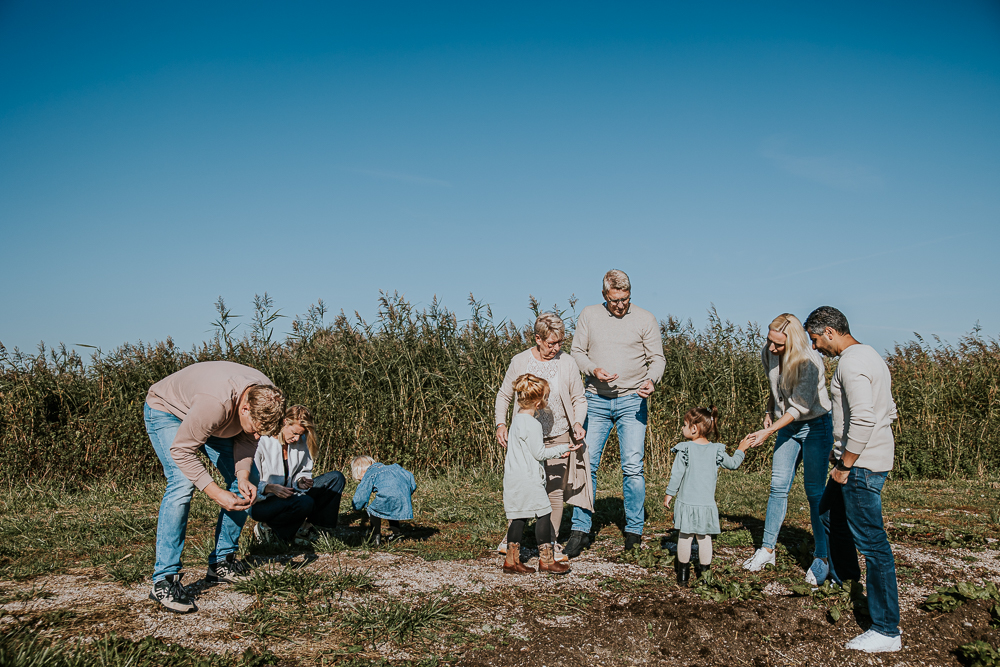 Familieshoot Friesland. De hele familie is schelpjes aan het zoeken in het Lauwersmeergebied. Lifestyle fotosessie door fotograaf Nickie Fotografie.