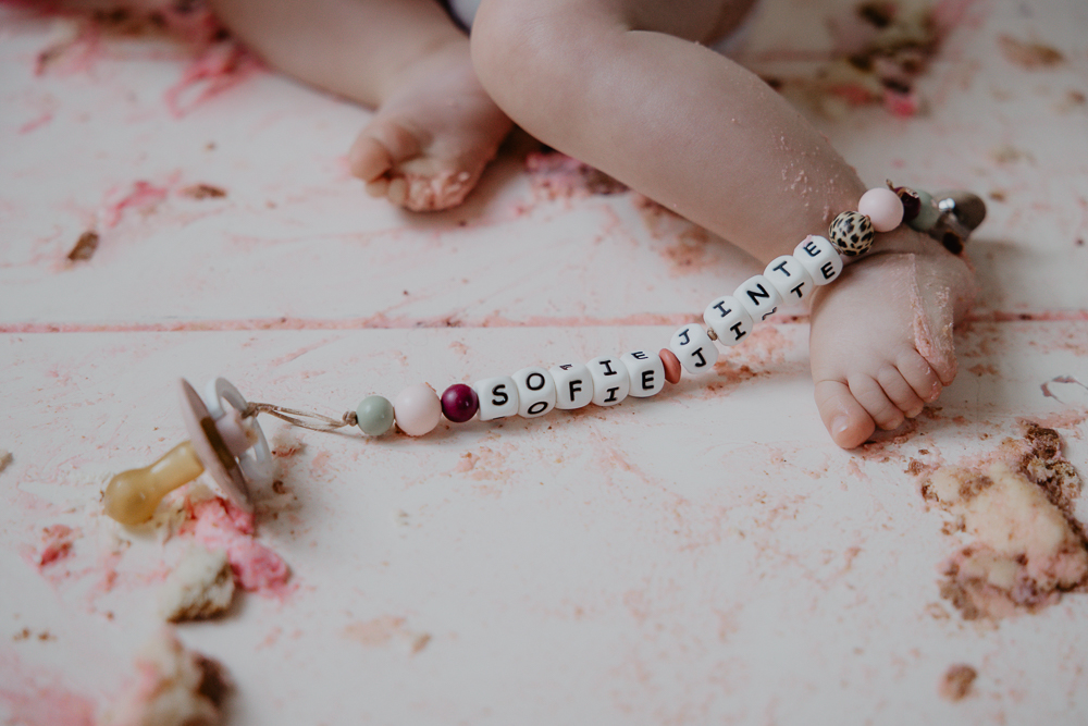 Speen met naamketting. Een vieze grond na het eten van de verjaardagstaart. Verjaardagsreportage door fotograaf Nickie Fotografie uit Dokkum, Friesland.