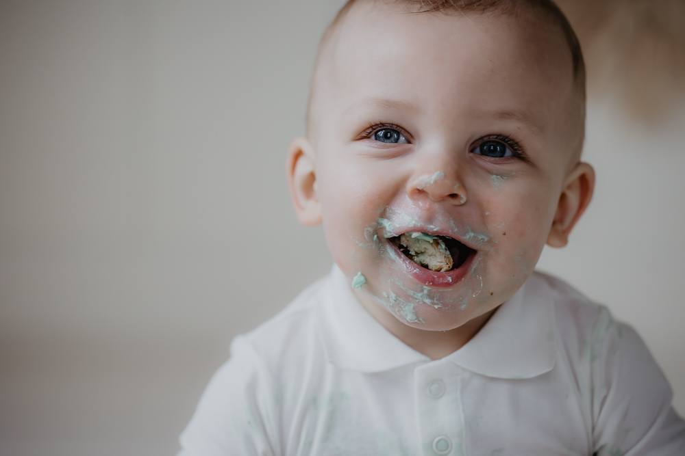 Cakesmash fotograaf Dokkum, Friesland. Close-up portret van dreumes met volle mond van de verjaardagstaart door Nickie Fotografie.